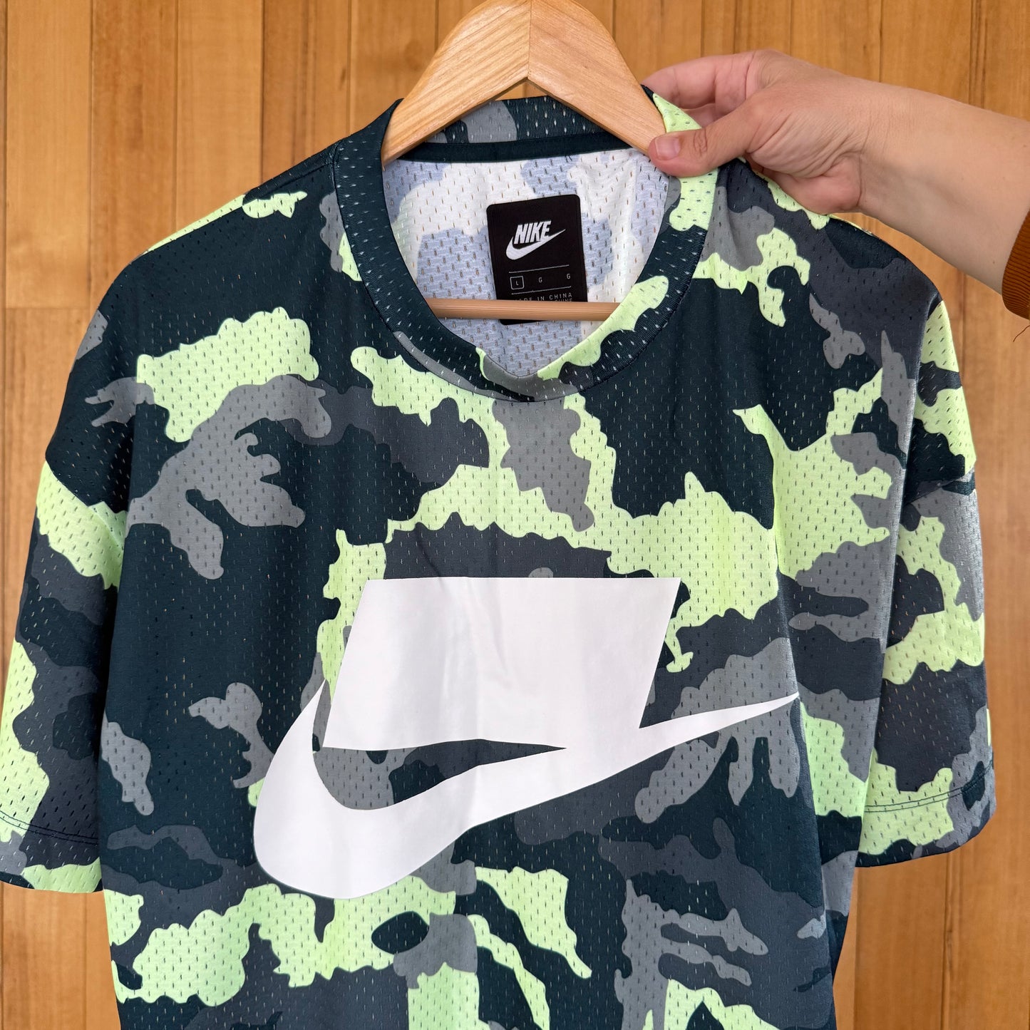 Close-up detail of white print on Nike Sportswear green and yellow camo mesh t-shirt in new without tags condition