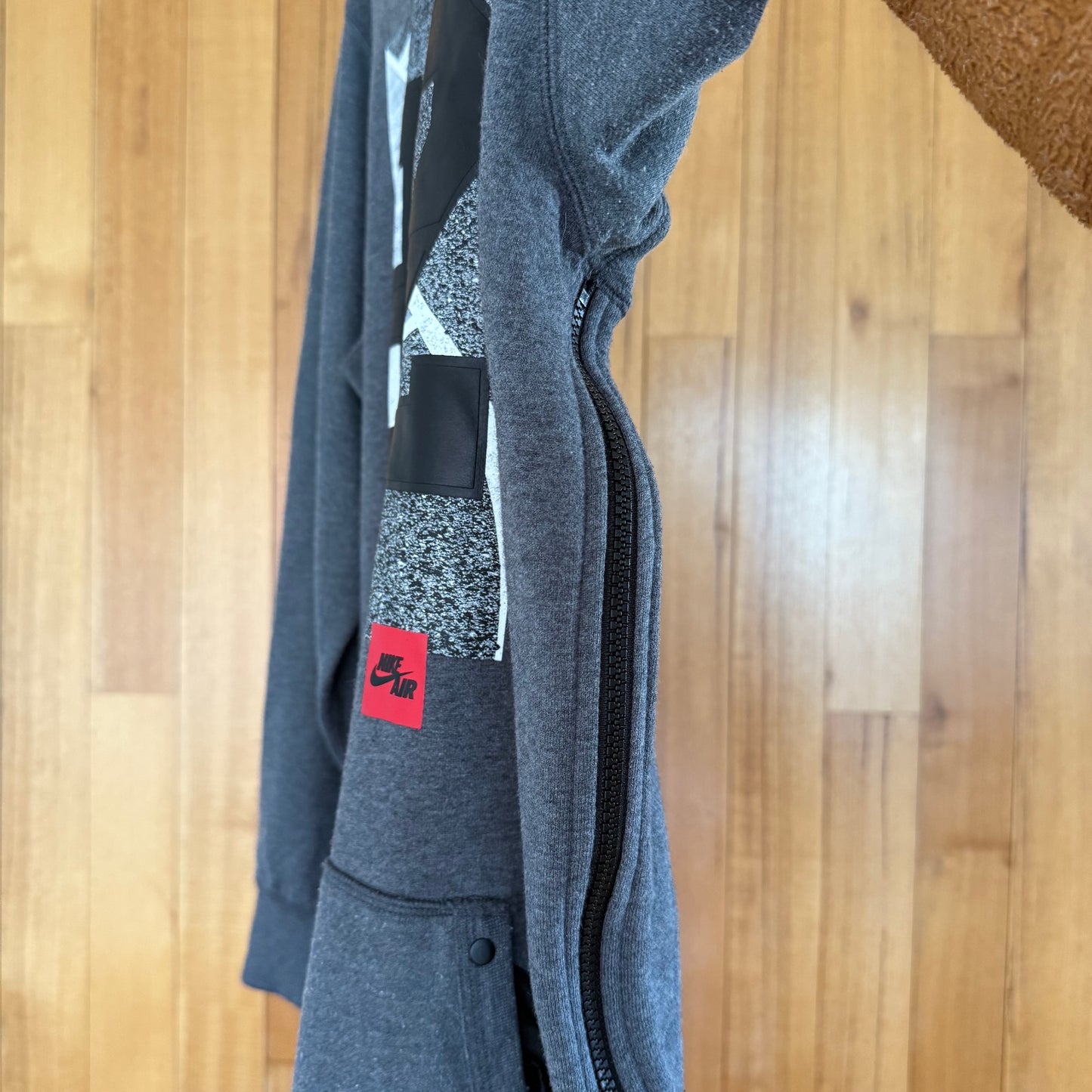 Close-up detail of zipper detail on Nike Air 92 grey crew sweatshirt in worn condition