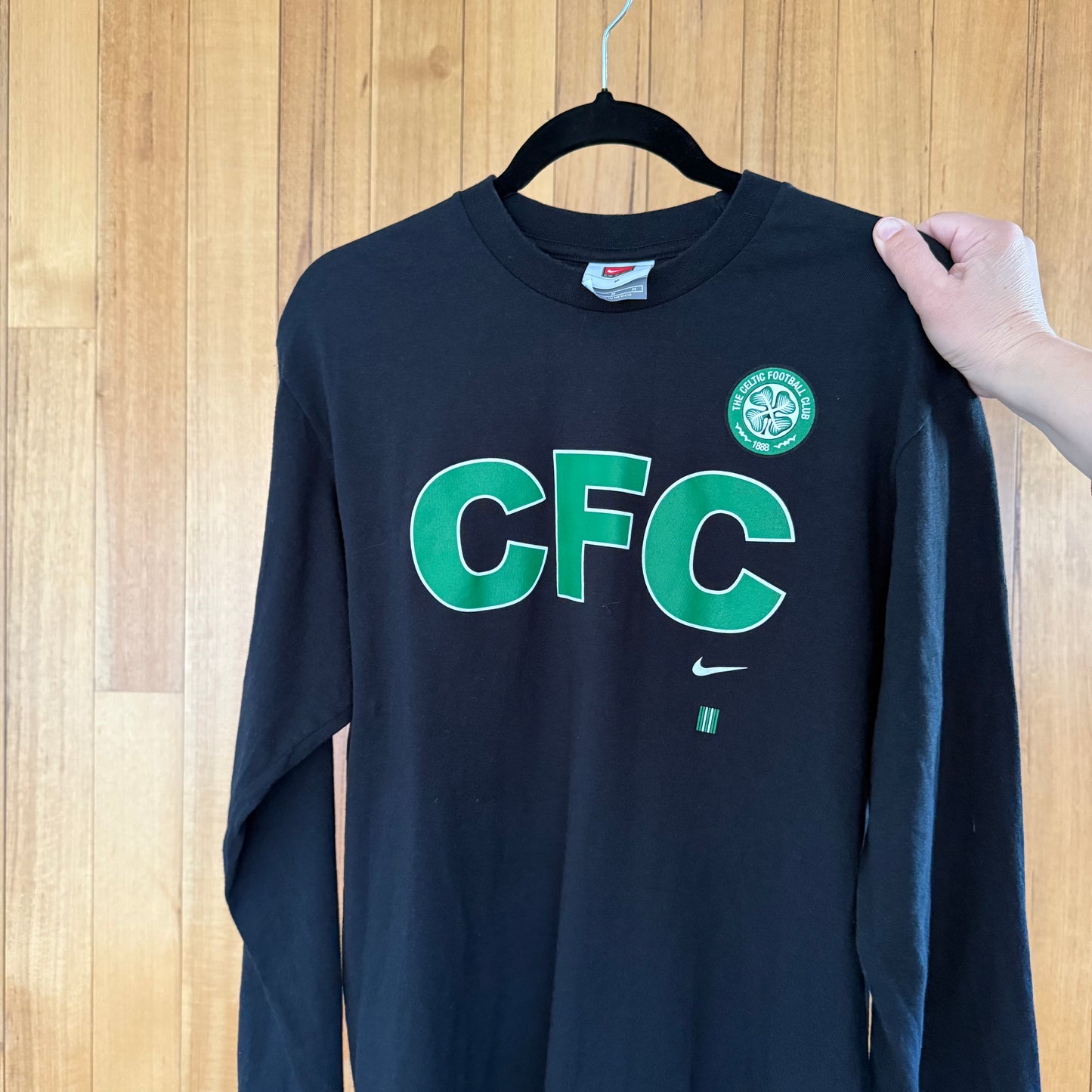 Close-up of Celtic Football Club logo on black Nike long-sleeve t-shirt