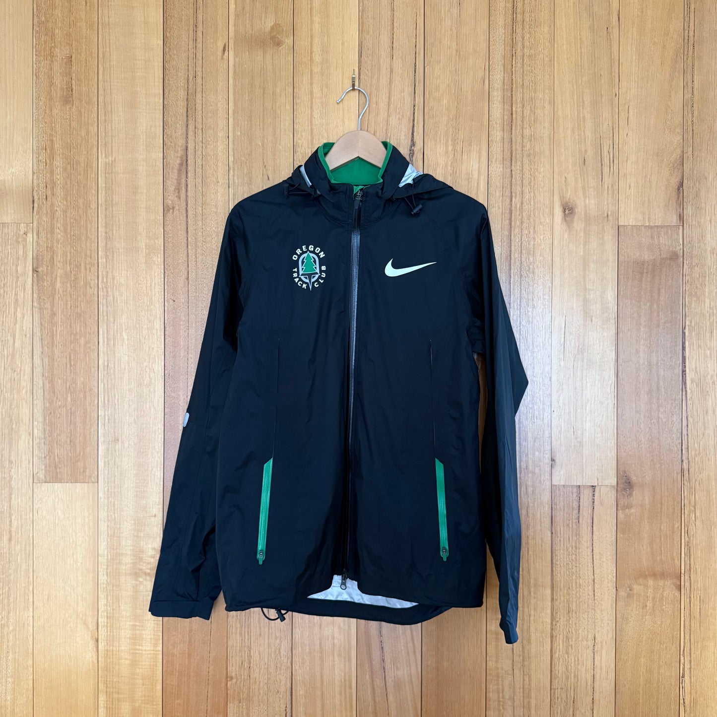 Nike Oregon Track Club Waterproof Jacket in black with green, silver and white accents - front view