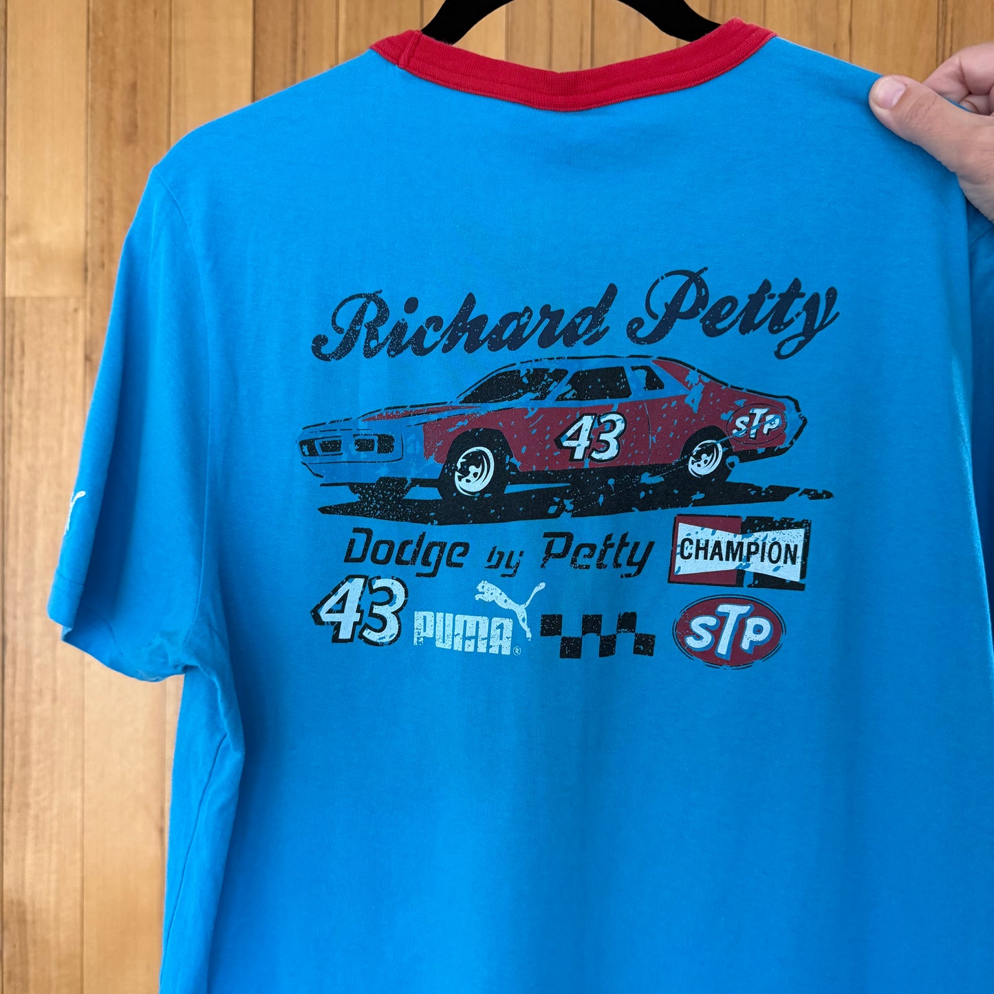 Close-up of STP racing logo and Richard Petty graphics on back of blue Puma t-shirt