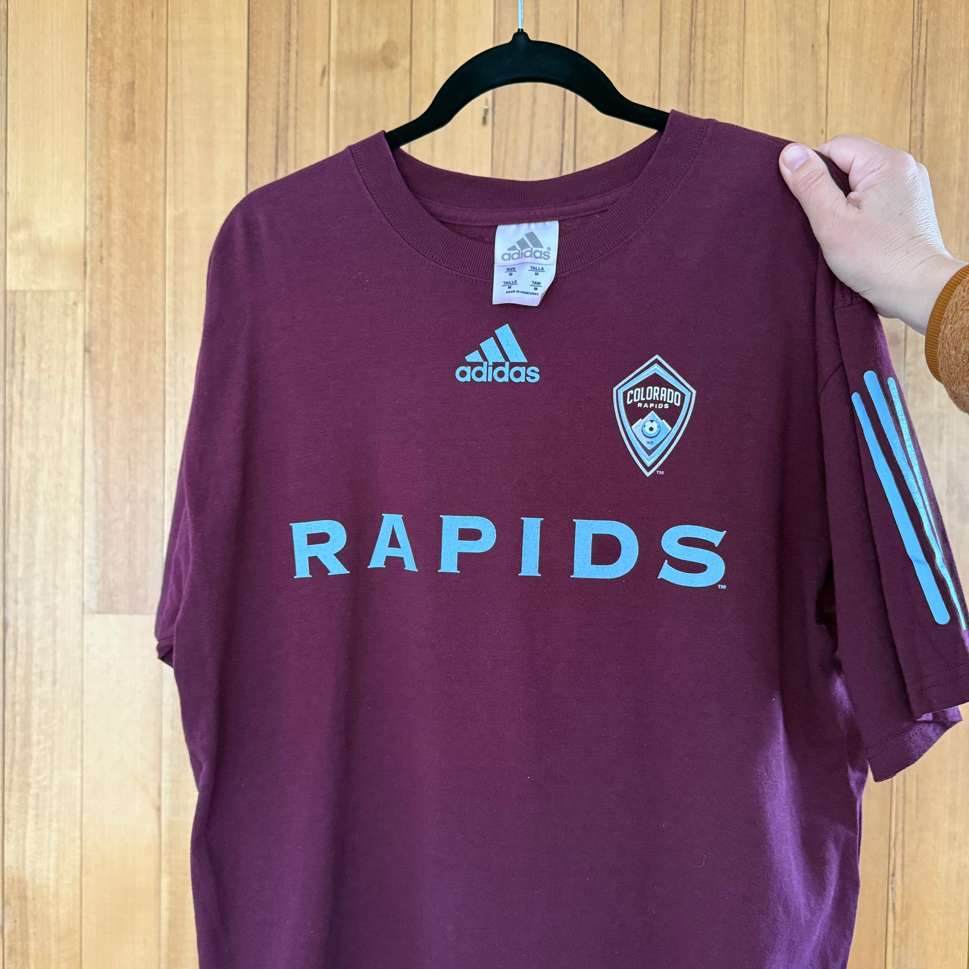 Close-up detail of blue print on Colorado Rapids purple Adidas soccer t-shirt in worn condition