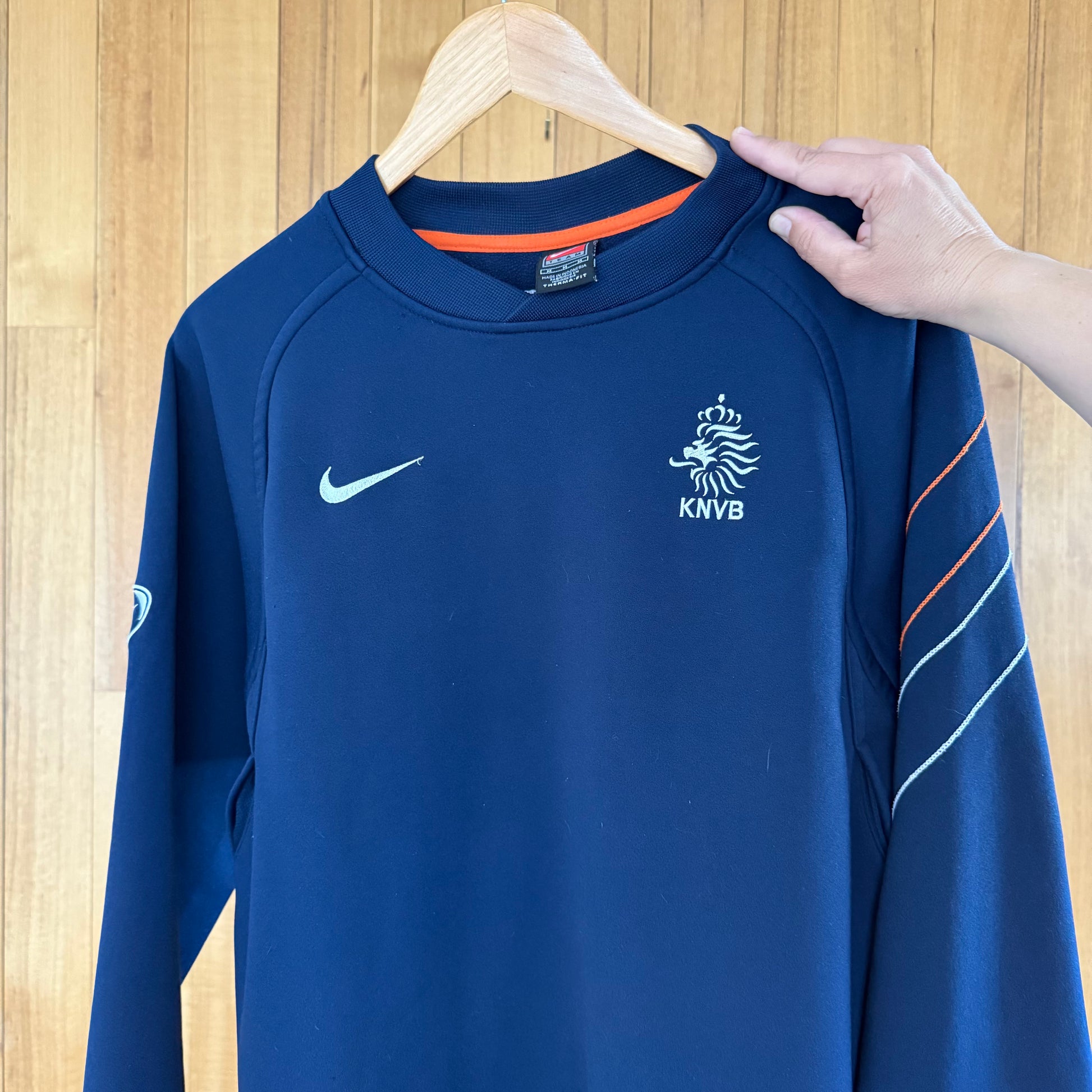 Close-up detail of orange and white print on Nike Netherlands KNVB blue crew sweatshirt
