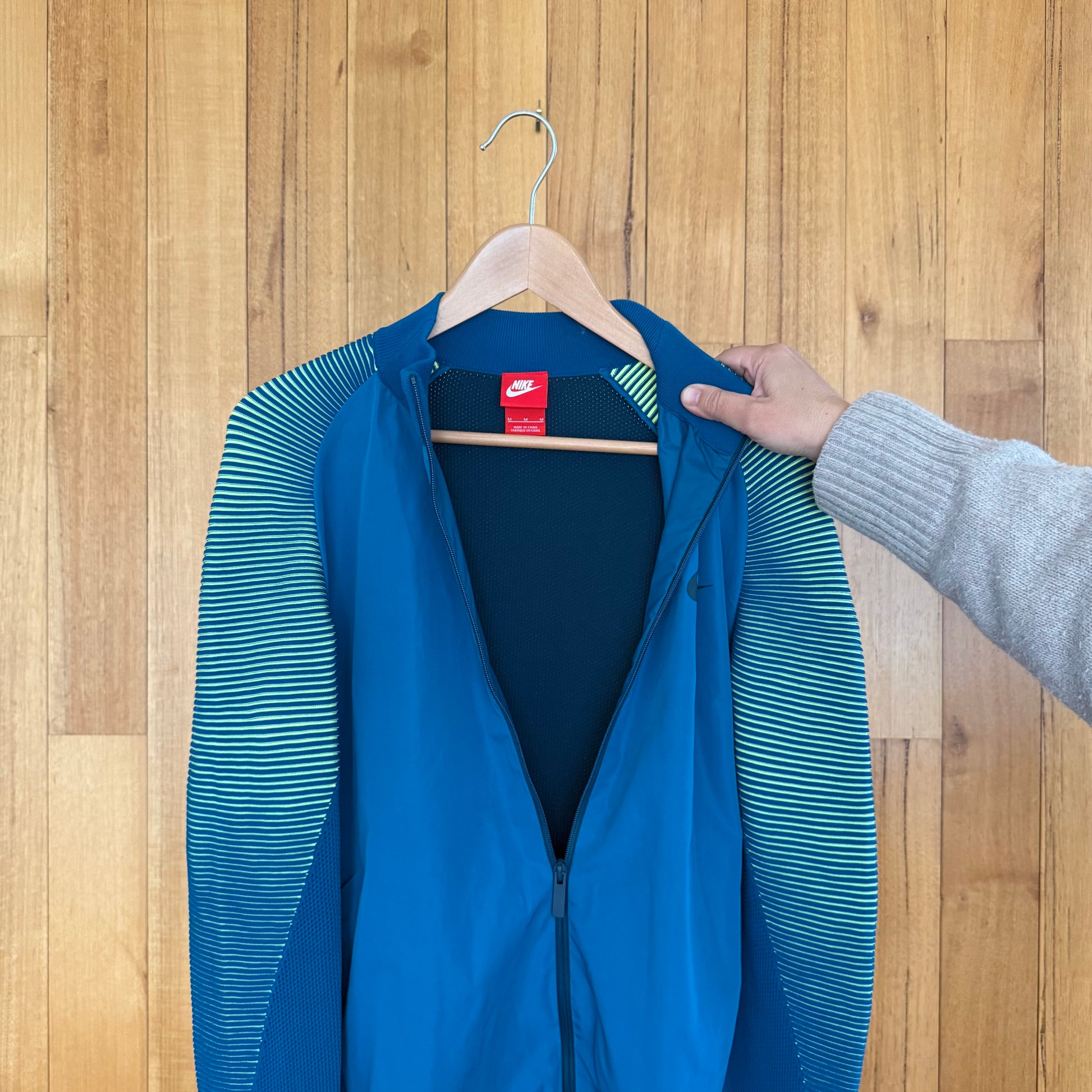 Nike label detail on turquoise Tech Knit Dynamic Reveal jacket