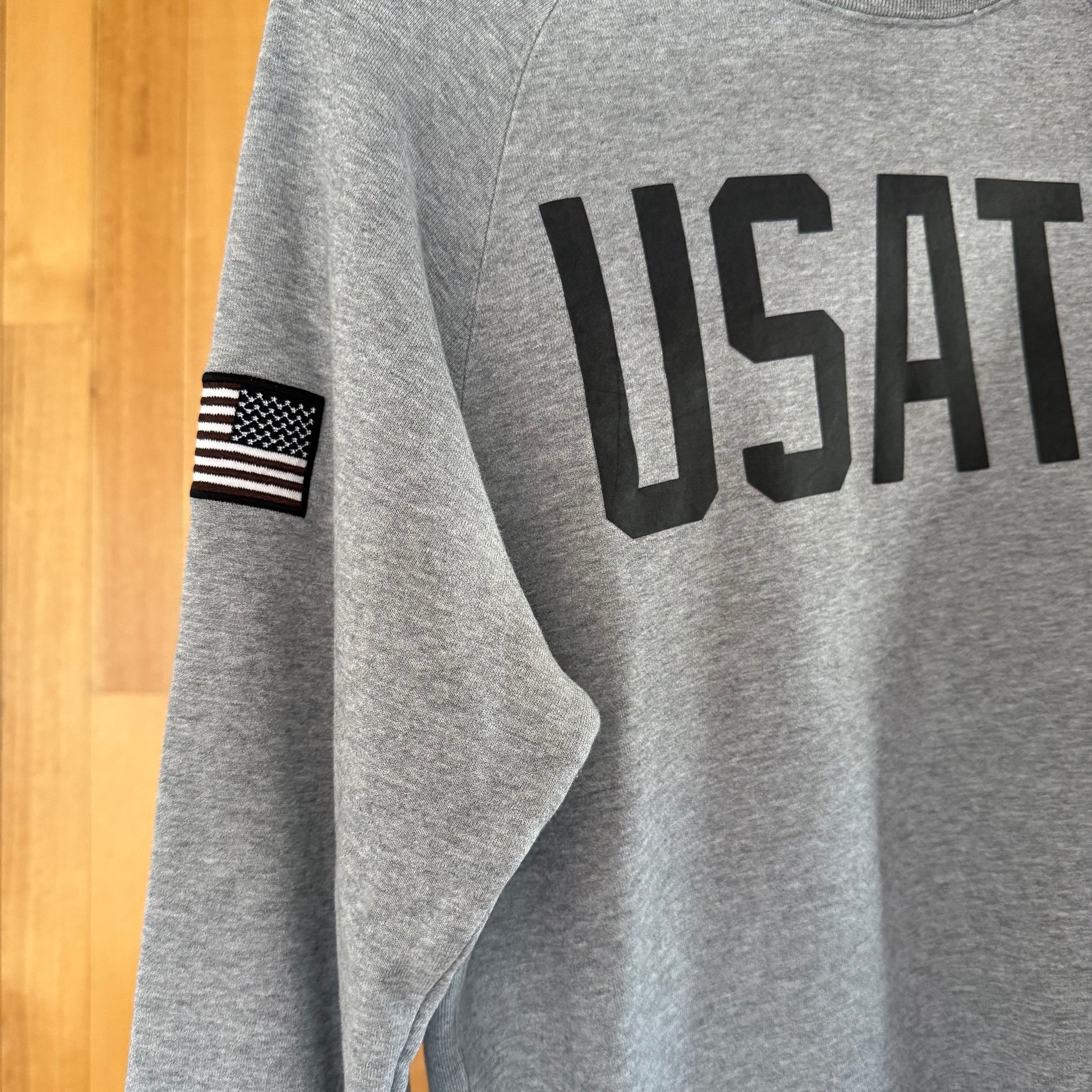 Close-up detail of dark grey print on Nike USATF grey crew sweatshirt