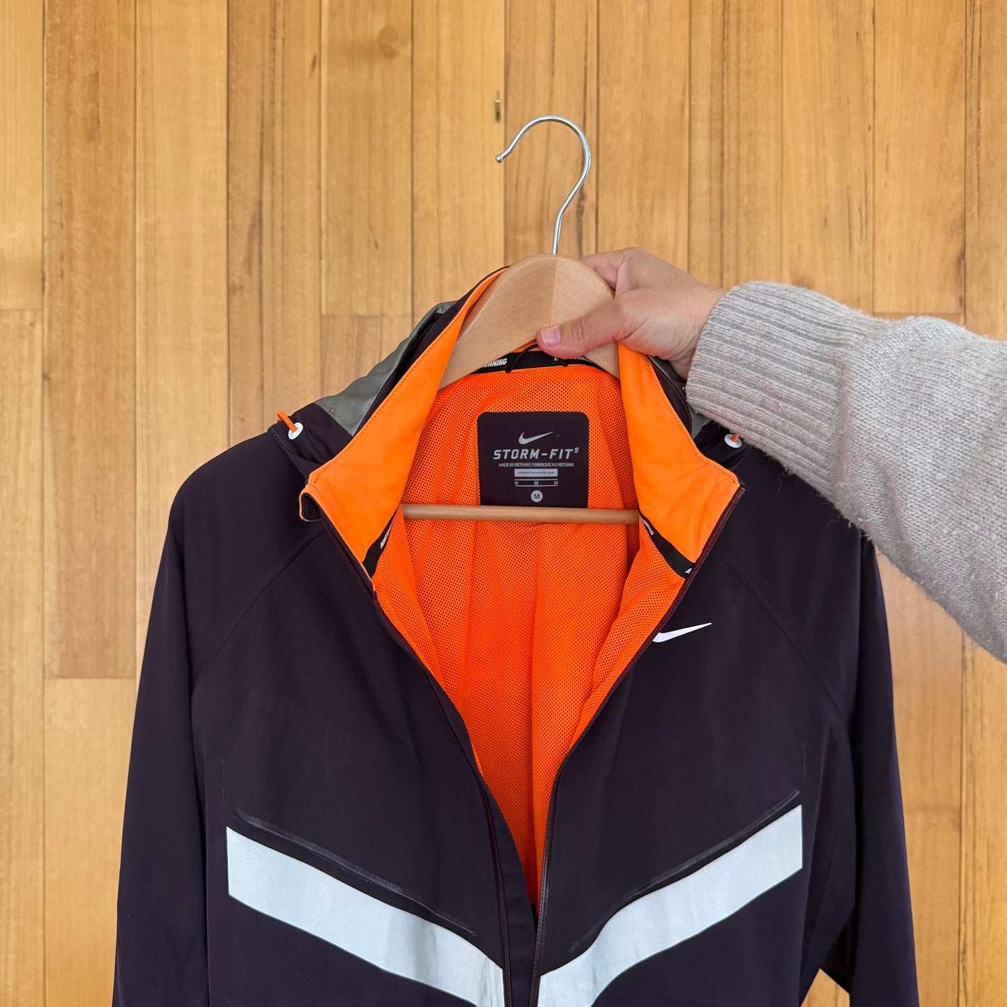 Label detail on maroon Nike Vapor Storm-Fit running jacket