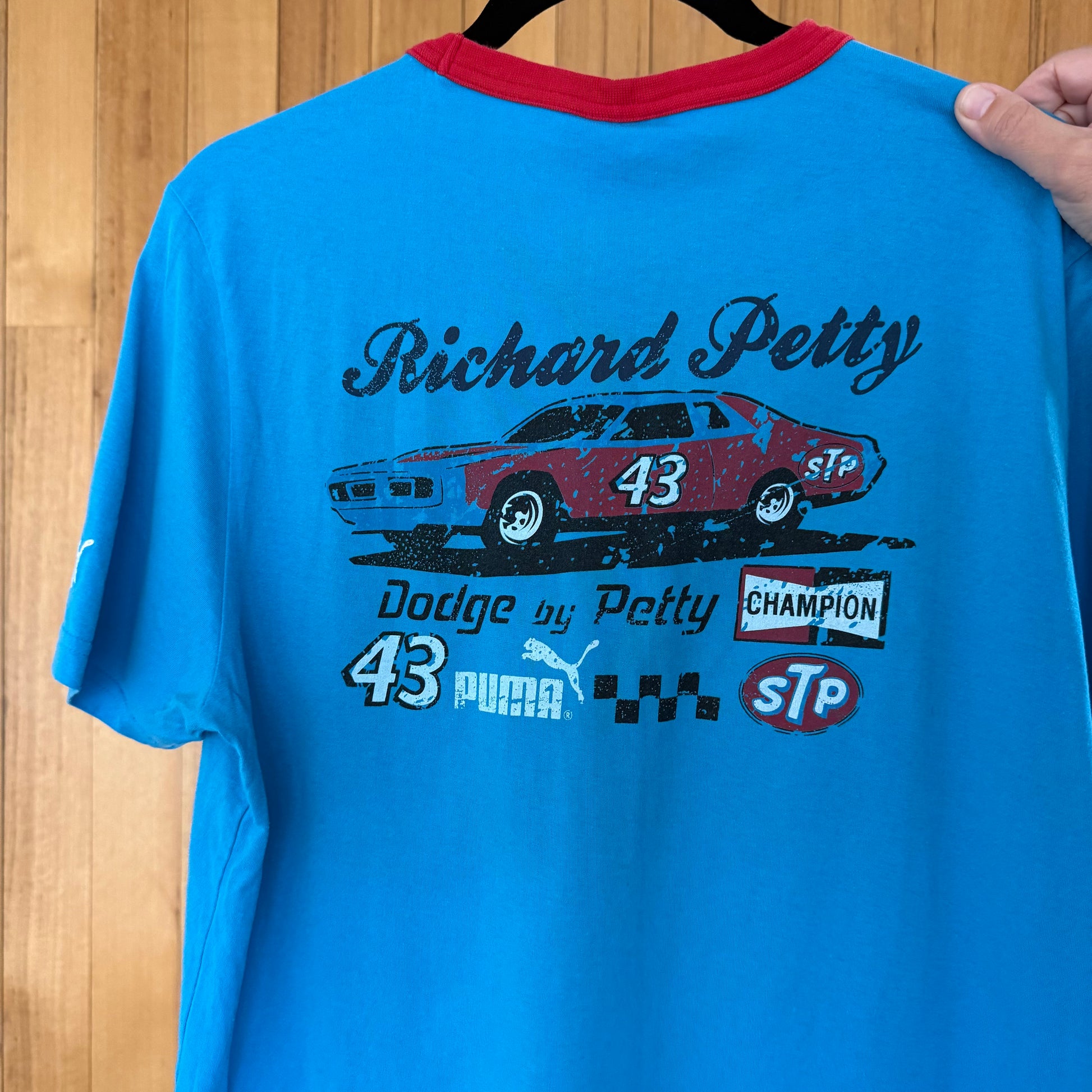 Close-up of STP racing logo and Richard Petty graphics on back of blue Puma t-shirt